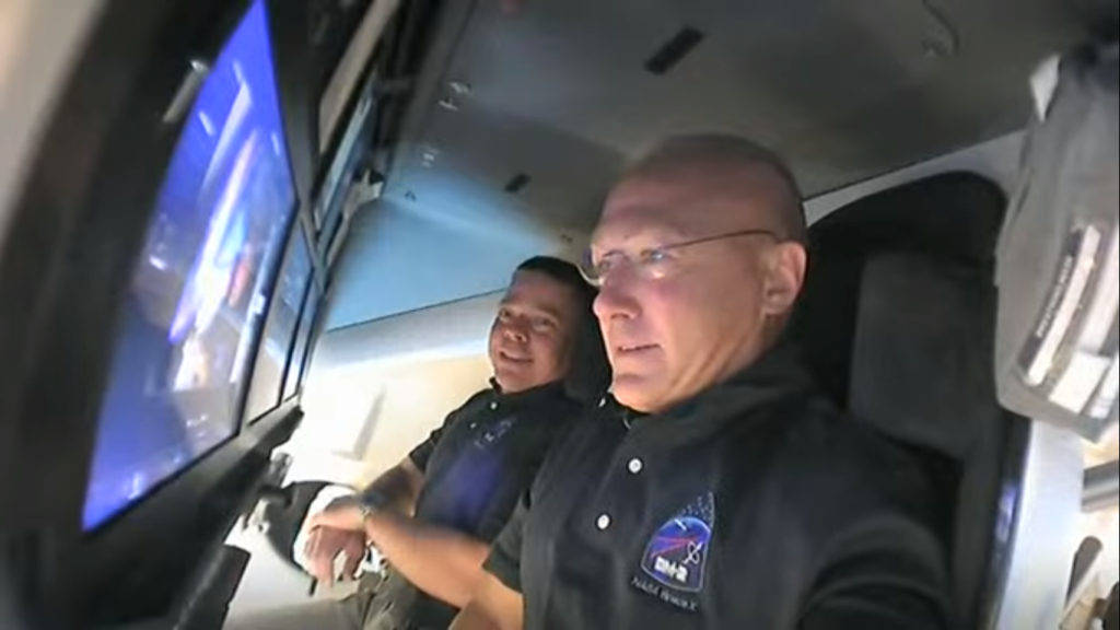 Os astronautas Robert Behnken e Douglas Hurley a bordo da cápsula Endeavor, indo em direção à ISS